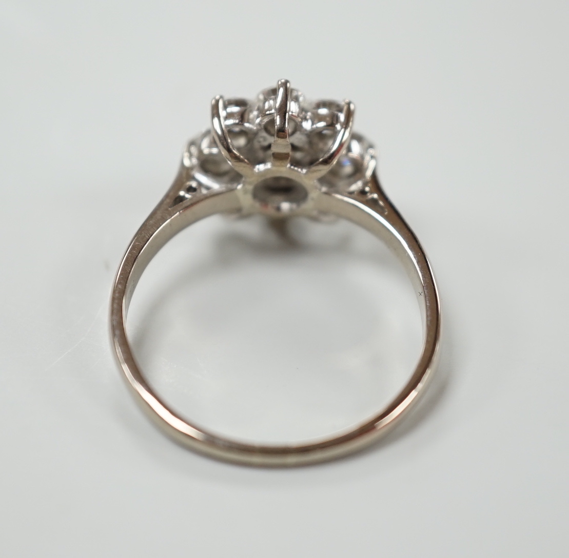 An 18ct, plat. and nine stone diamond set flower head cluster ring, the central stone weighing approximately 0.25ct, size O, gross weight 4 grams.